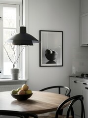 Minimalist kitchen dining area with a round wooden table and black chairs. a black pendant light. and a framed black and white still life print on the wall
