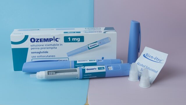 Qawra, Malta - 01.11.2024 - Ozempic 1mg packaging with two injector pens, needles, and alcohol wipes on blue and pink background. High quality photo