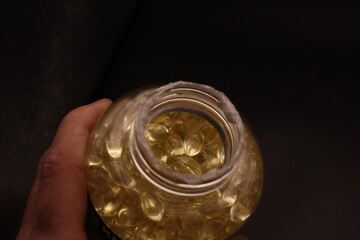 A unique perspective looking down into a bottle filled with softgel vitamins. The glossy capsules create a vibrant and textured pattern, showcasing their quality and appeal.