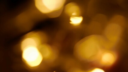 Blurred warm yellow lens flare motion studio lightning, garland with bokeh effect on dark background. Light leaks, abstract background footage.