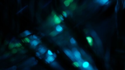 Blurred blue green lens flare motion studio lightning, garland with bokeh effect on black...