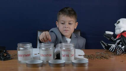 Child in a busiess suit with sceptic face expression putting coins in a jar for Education savings. High quality photo