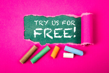 Try Us For Free. Text under torn purple paper on a green chalkboard