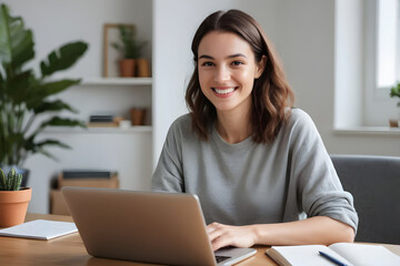 Smiling woman working remotely from home office using laptop