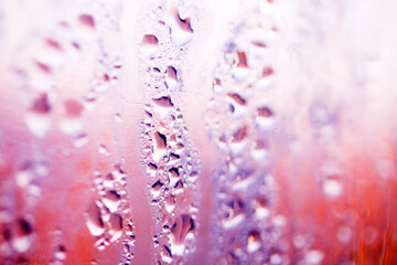Deilcate Rain Drops of Water on Glass in a Red Pink Glow for Background