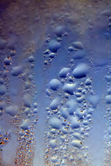 Deilcate Rain Drops of Water on Glass in a Blue Glow for Background