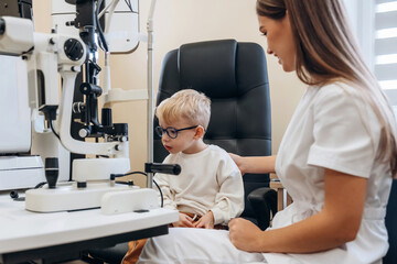 In the glasses. Little boy is having check up in the ophthalmologist cabinet