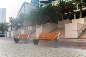 Benches without people on an empty street early morning.