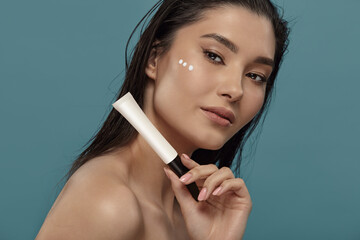 Well groomed woman holds small white cosmetic tube mockup.