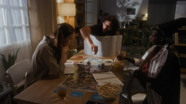 Group of three diverse friends enjoying role-playing fantasy tabletop game during party at home