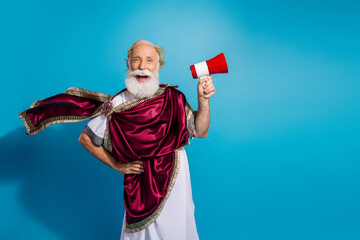 Photo of funny old man actor dressed as philosopher politician in traditional toga isolated on blue...