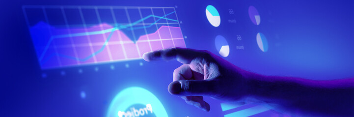 Hand exploring vibrant digital graphs and pie charts in futuristic blue environment. Ideal for...