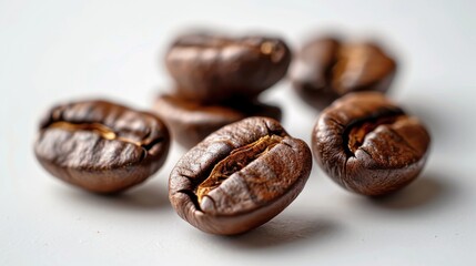 Fototapeta premium Group of coffee beans with visible oils on a white background, macro photography