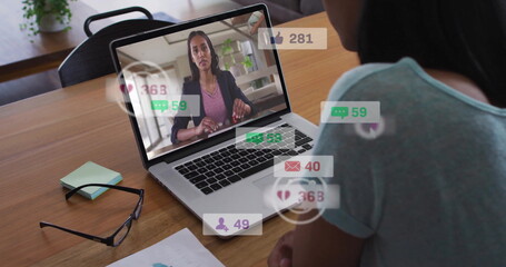 Image of icons and numbers over diverse business people using laptop in office