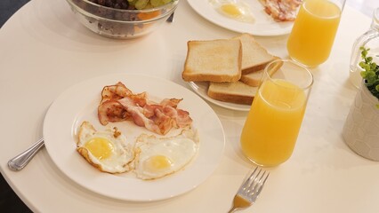 Fototapeta premium Traditional morning breakfast with bacon and eggs is served at table Egg yolks glisten adding an attractive touch to hearty breakfast Perfect combination of bacon and eggs for cozy morning atmosphere
