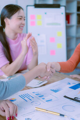 Seal the deal with a laptop and visual financial graphs. Business handshake over laptop and financial report documents