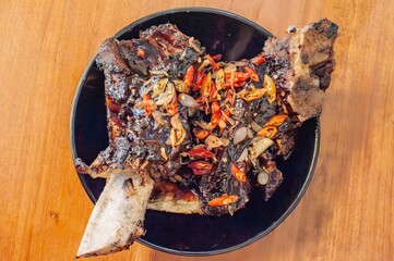 Indonesian culinary tradition at its finest: succulent grilled ribs marinated in a blend of aromatic spices, served with a fiery chili topping. 