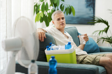 Exhausted man suffering from the heat at home