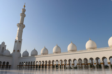 Minaret and domes of Sheikh Zayed Grand Mosque with blue sky in the background