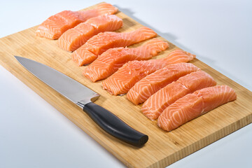 Salmon fillets sliced on a wooden board