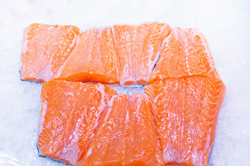salmon steaks on ice in a container in a supermarket