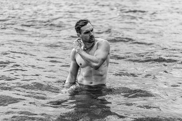 Junger sportlicher aktiver dynamischer Mann im Wasser beim Schwimmen und Fitness Training
