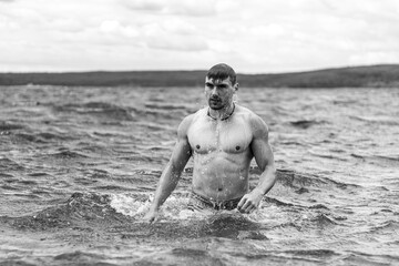 Junger sportlicher aktiver dynamischer Mann im Wasser beim Schwimmen und Fitness Training