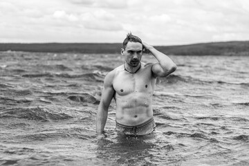 Junger sportlicher aktiver dynamischer Mann im Wasser beim Schwimmen und Fitness Training