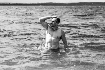 Junger sportlicher aktiver dynamischer Mann im Wasser beim Schwimmen und Fitness Training