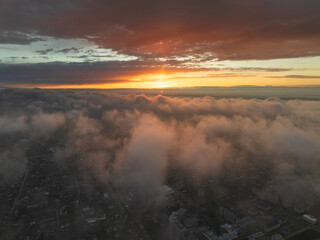 Drone view of the town and mountains at sunset. Beautiful clouds covered the city. Golden sunset....