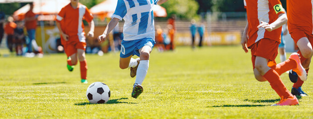 Boys playing soccer game. Happy kids compete in football game. Kids having fun in sport. Running...