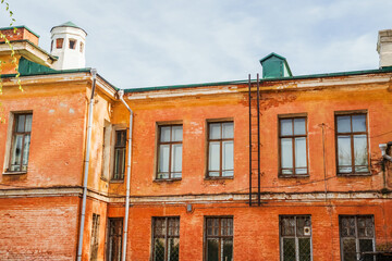 Fototapeta premium Autumn light illuminates the worn facade of a historic building in Irkutsk, showcasing its unique architectural style. Irkutsk city, historical building.