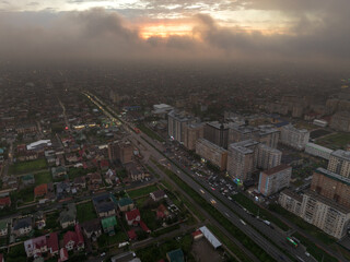 Drone view of the town and mountains at sunset. Beautiful clouds covered the city. Golden sunset....