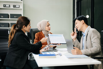  Asian businesspeople while collaborating on a new project.  using a laptop and tablet