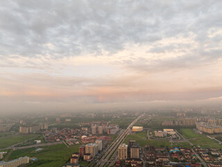 Drone view of the town and mountains at sunset. Beautiful clouds covered the city. Bright evening...