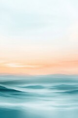 Fototapeta premium A serene landscape with soft waves of blue and teal hues under a pastel orange sky.