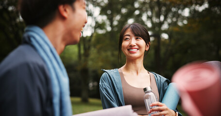 Happy, yoga and friends in nature with conversation for health, wellness and balance in morning. Smile, talking and group of Japanese people outdoor for pilates workout or yogi exercise in park.