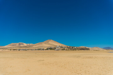 A breathtaking view of Playa de Sotavento de Jand&iacute;a, Fuerteventura, Canary Islands, Spain. The photo captures the vast expanse of turquoise water, golden sand dunes, and the volcanic landscape