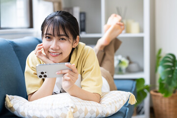 スマホで動画を見る若い女性