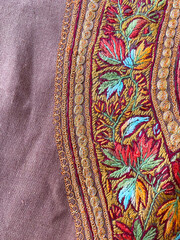 Intricate multi colored hand thread kashmiri embroidered floral border on brown woolen fabric