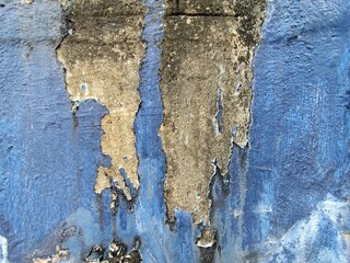 Old blue concrete wall with cracks and scratches. Abstract background for design.
