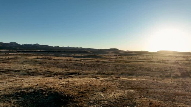 Drone video of a winter's sunset in the ranch lands of Arizona outside of Chricahua Naional Monument during a winter day with beautiful blue sky in the background