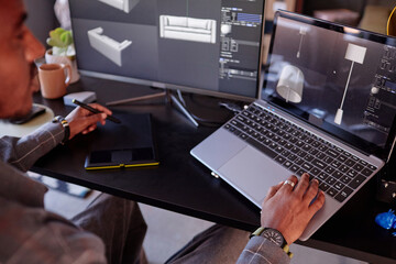 Designer is focusing on creating detailed interior models on laptop while using graphic tablet and...