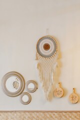 A bohemian-style wall mirror with a sunburst design and a natural wood frame.
