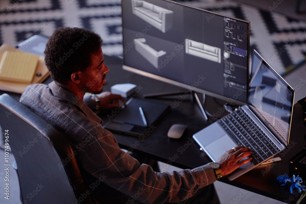 Poster african american man working with virtual 3d models on dual computer screens in dark room with focus