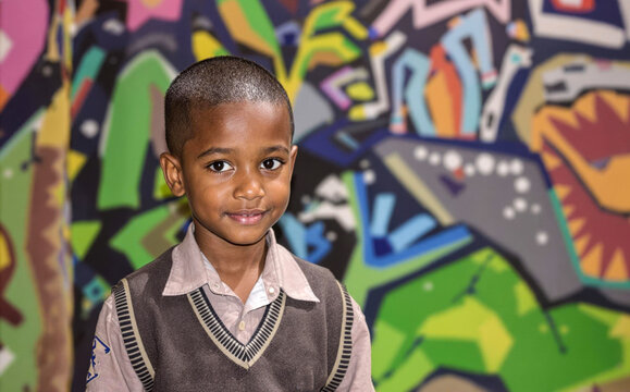 Smiling Boy In School Uniform With Colorful Graffiti Background