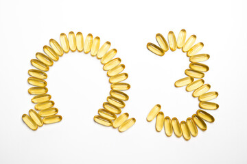 Golden Omega 3 Capsules Forming a Health Symbol on White Background