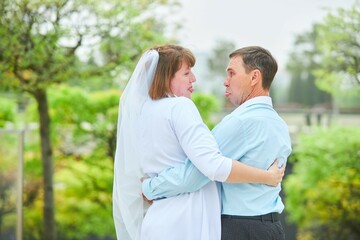 Obraz premium An adult bride and groom . Husband and wife's wedding anniversary photo shoot. We've been together for 30 years.