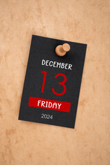 Calendar Friday the 13th December 2024 and wooden push pin on old paper.