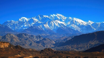 Obraz premium Majestic Snow-Capped Mountain Range Under Bright Blue Sky